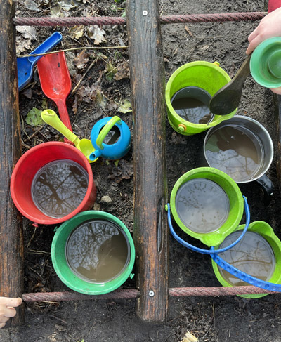 Kinder spielen im Regen mit Matsch 