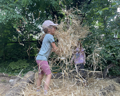 Kind spielt im Stroh